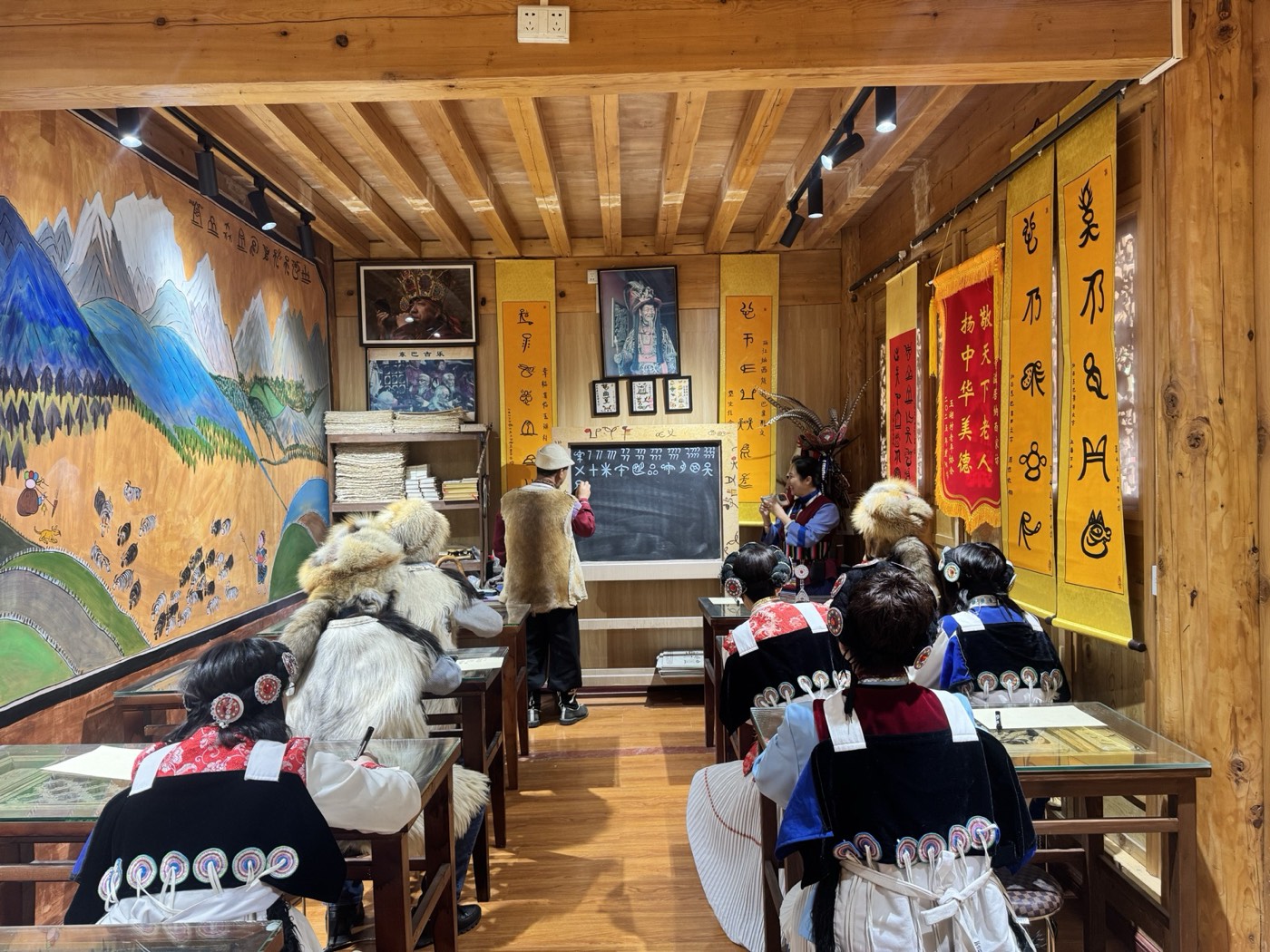 A Dongba script class with Naxi women in seven-star sheepskin capes in Lijiang